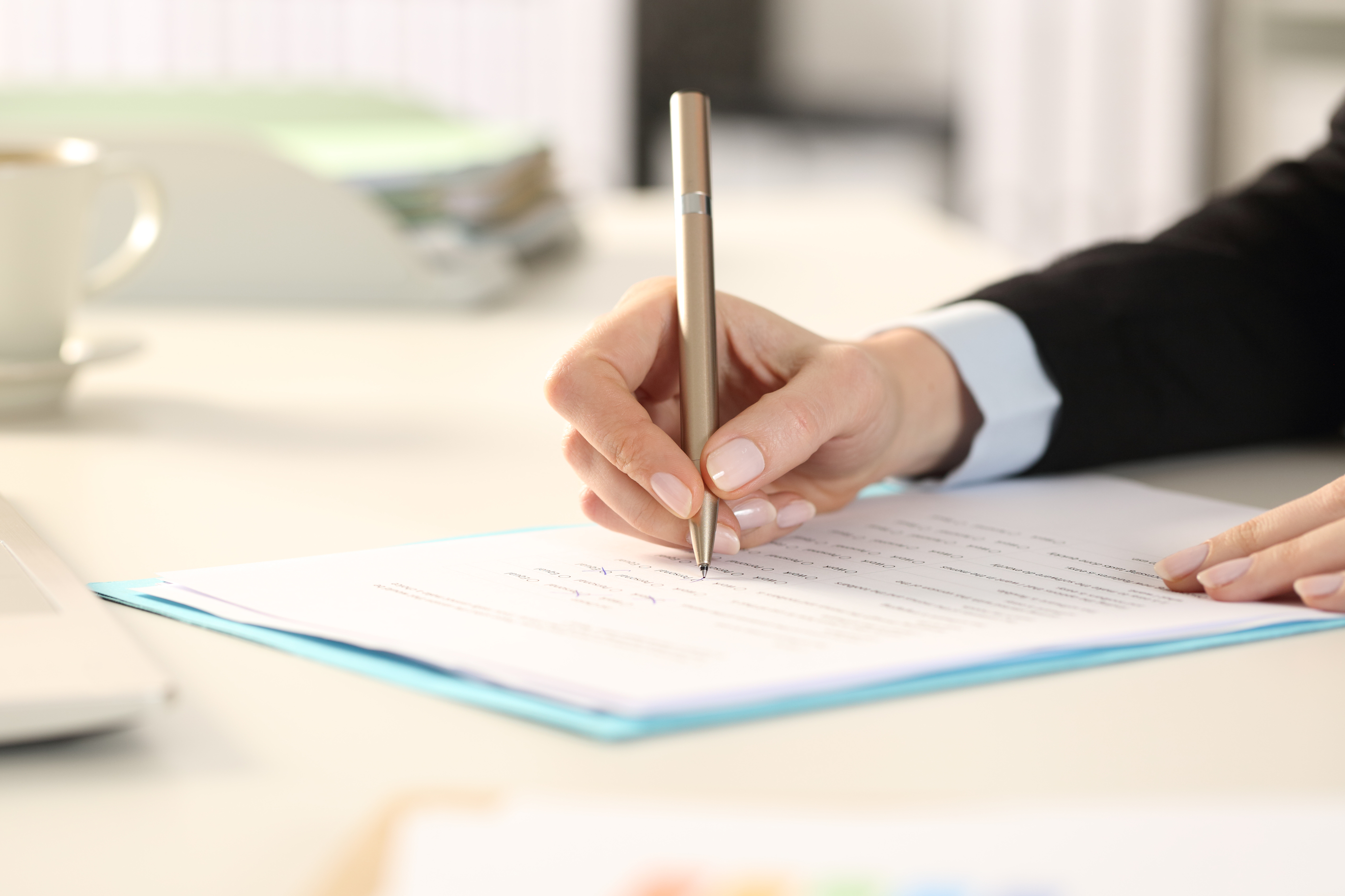 person filling out a survey with a pen